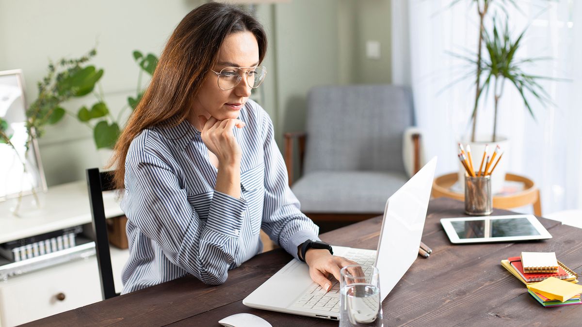 woman doing freelance work on laptop at home 