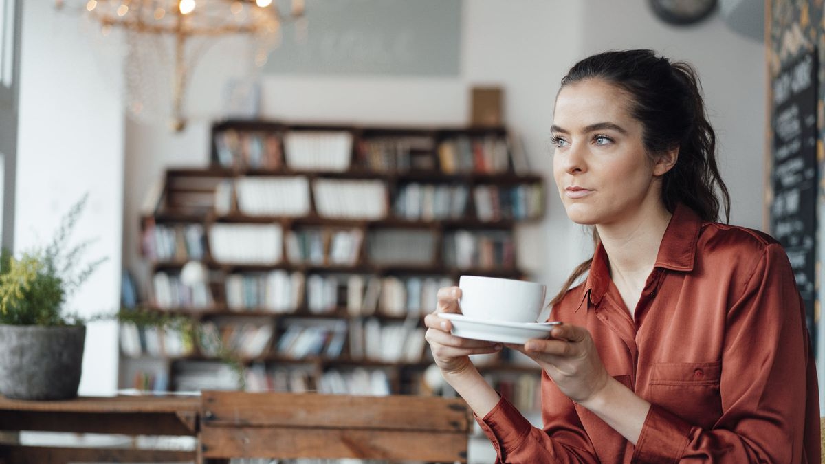 Woman drinking coffee thinking about how to prepare for a recession