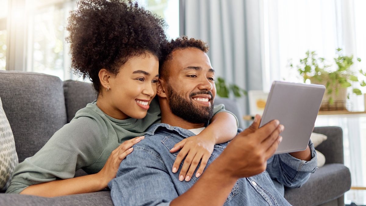 Couple reading on a tablet about how much to save in an emergency fund