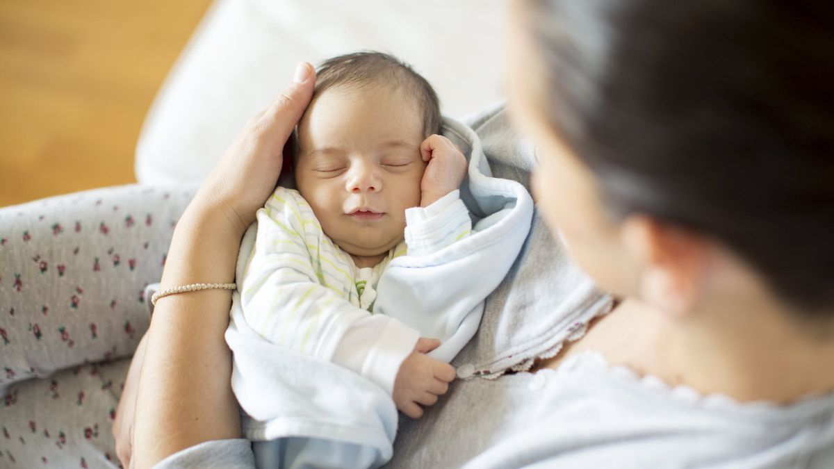 a woman holding a newborn baby