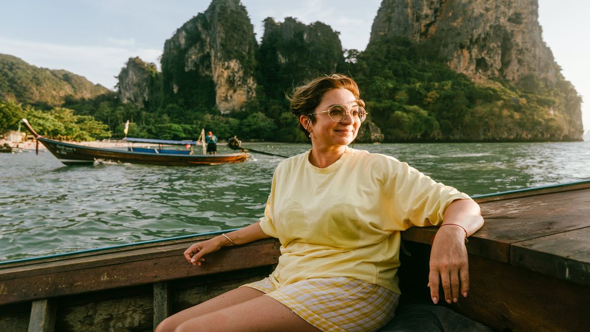 woman smiling and enjoying a boat ride on a solo trip