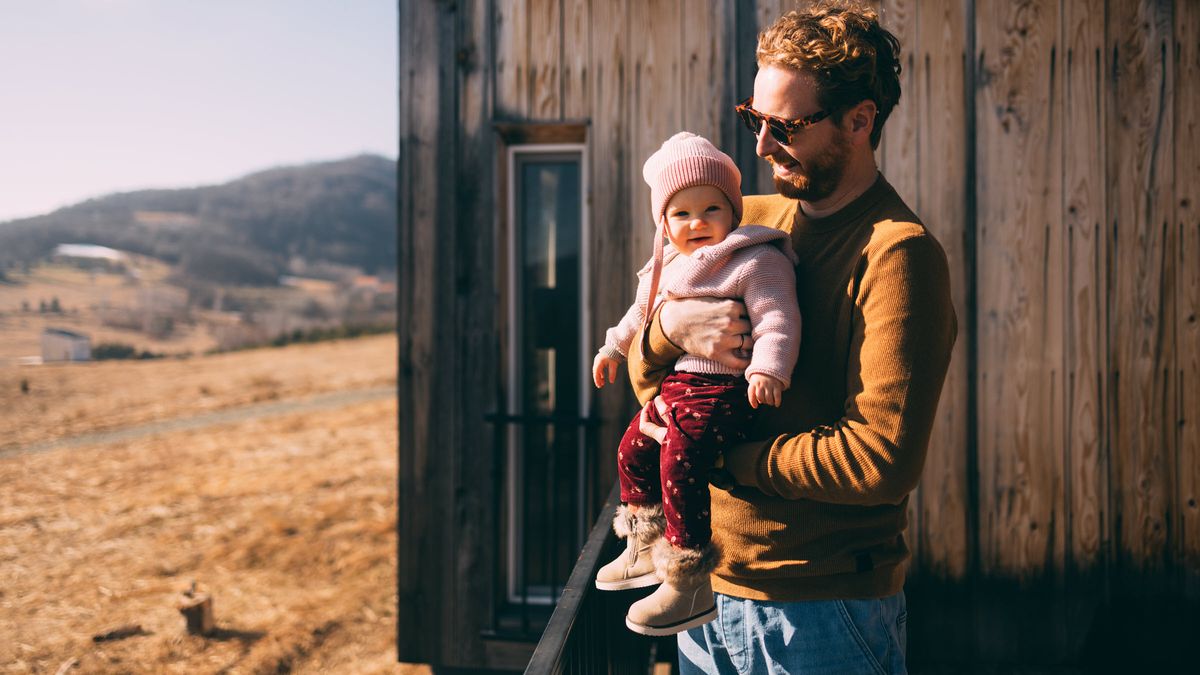 Father holding his new baby and contemplating if Trump Accounts could fit into his financial plan.