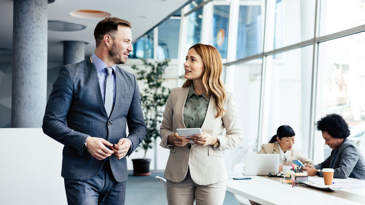 Coworkers discuss investment strategy in modern office   