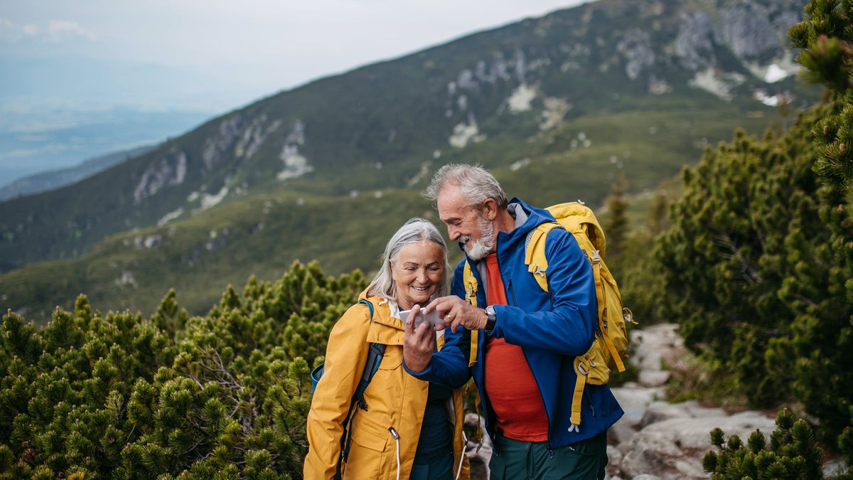 Portrait of senior woman hiking with husband in autumn mountains,    celebrating financial freedom with a secure financial plan from Northwestern Mutual.