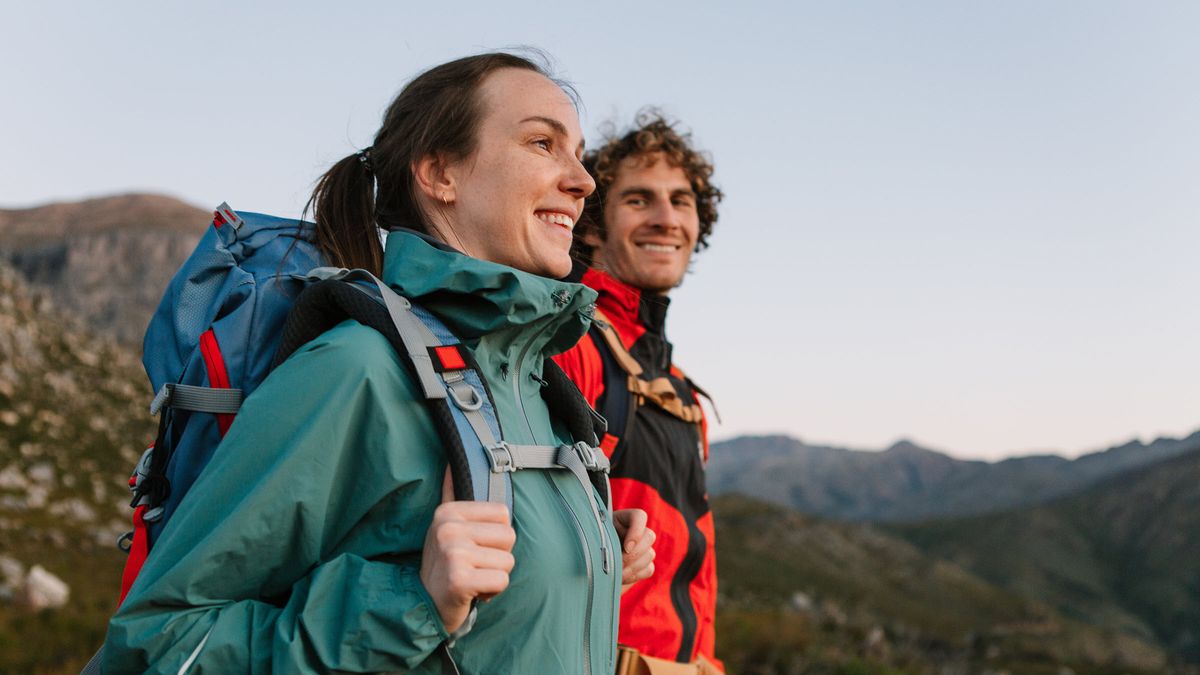 Happy couple enjoys long hike in the wilderness, celebrating their confidence thanks to a long-term plan with Northwestern Mutual