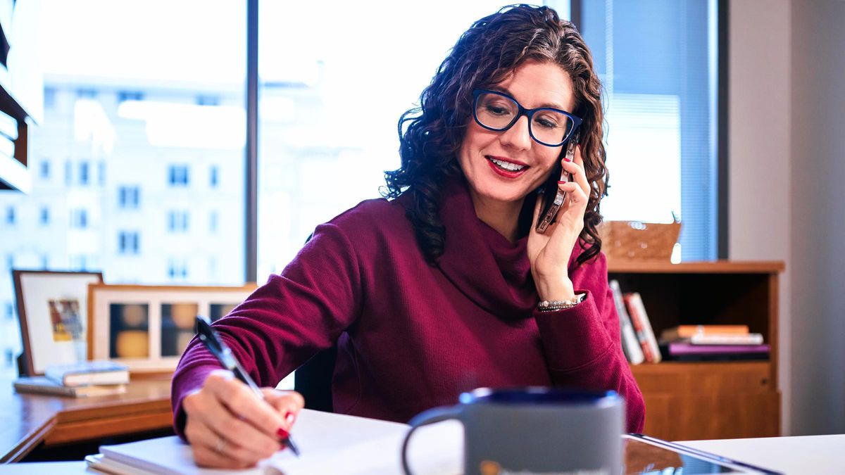 Woman financial advisor talking on the phone and taking notes