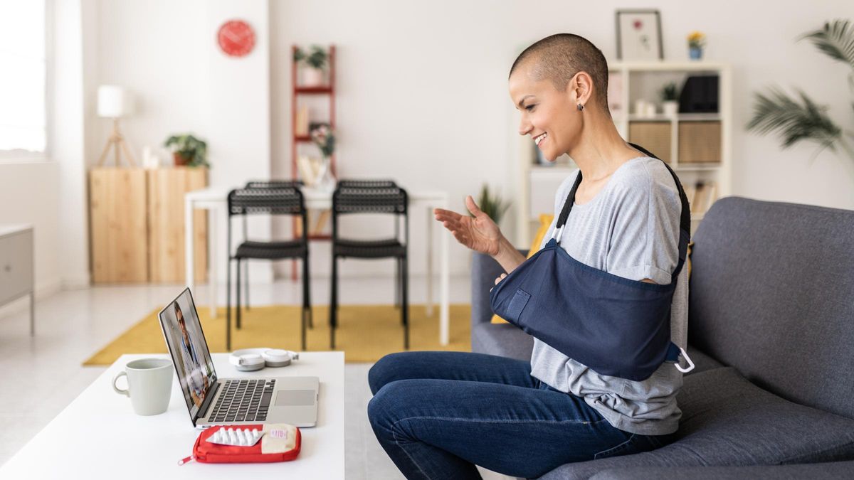 Woman in an arm sling using a laptop for a video call