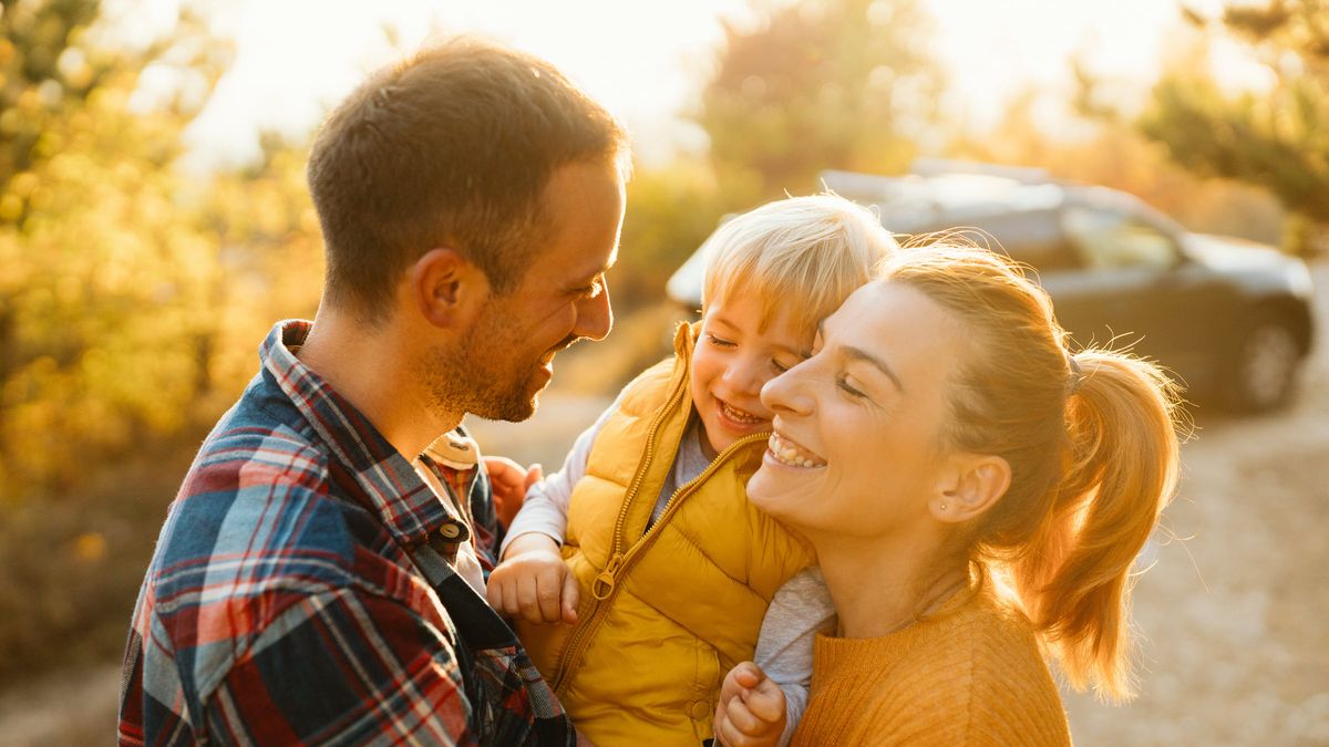 Happy couple with their child talking about how to make their money last in retirement.