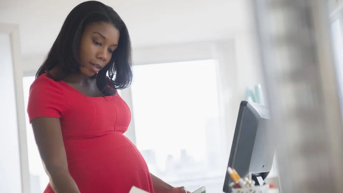 Pregnant woman on the computer with papers