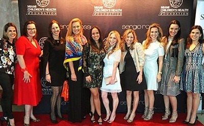 Darling (fifth from the left) hosts a “Premier” table at the Wine, Women and Shoes luncheon and fashion show.