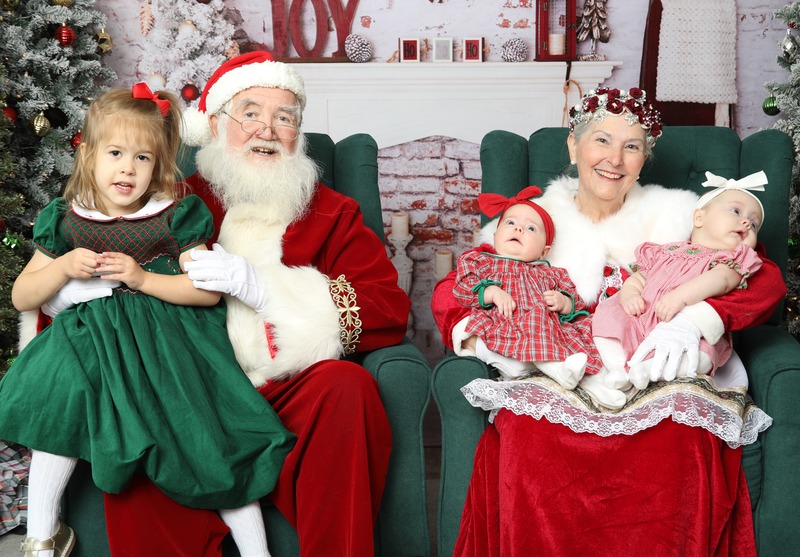Amelia, Natalie, and Madeline meeting Santa and Mrs. Clause.