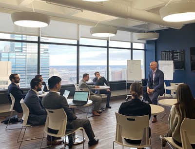 a photo of a group of people in suits learning with their laptops