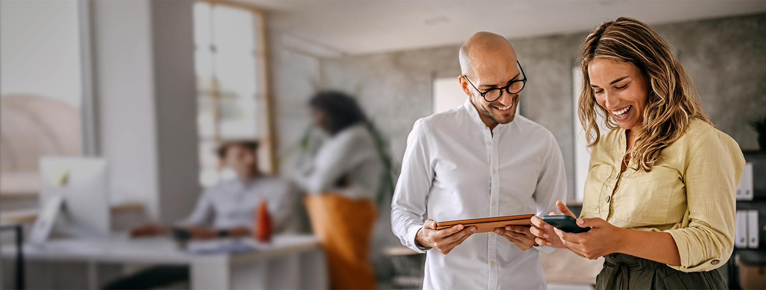 Business woman and man going viewing reports on their tablet.