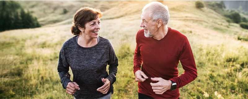 Older couple walking in grass together